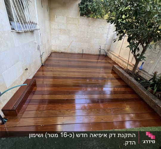 דק עץ רטוב עם צינור השקיה וגינה קטנה